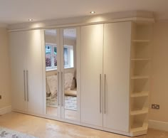 an empty room with large white closets and shelving unit in the corner,