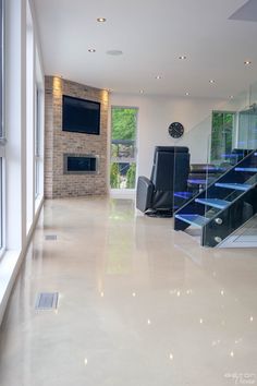 an empty living room with stairs leading up to the second floor and television on the wall