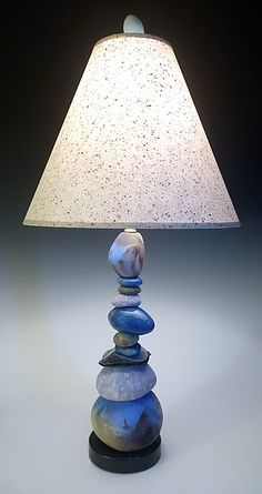 a lamp that is sitting on top of a table with rocks in front of it