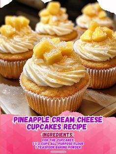 cupcakes with white frosting and pineapple toppings are on a wooden tray