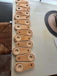 wooden spoons are lined up on a table next to a straw hat and wicker basket