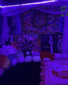 a bed with stuffed animals on top of it in a room filled with purple lights