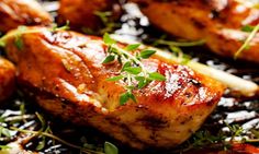 closeup of meat and vegetables on a grill with garnishes in the foreground