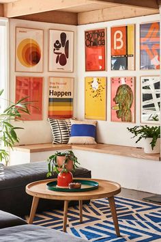 a living room filled with furniture and pictures on the wall above it's coffee table