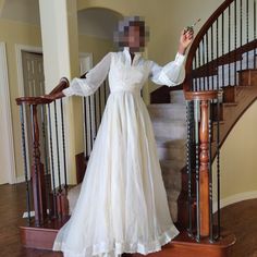 a woman in a wedding dress standing on the stairs