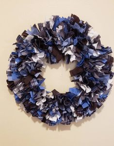 a blue and white wreath hanging on the side of a wall next to a toilet paper roll