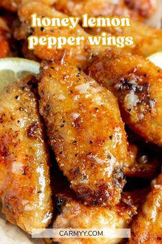 honey lemon pepper wings on a plate with lemon wedges in the foreground and text overlay that reads honey lemon pepper wings