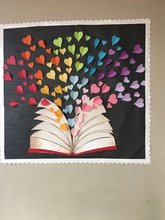 an open book with hearts coming out of it on a black background and white border