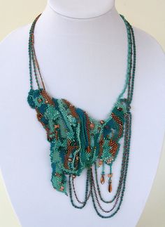 a necklace with beads and chains on a mannequin