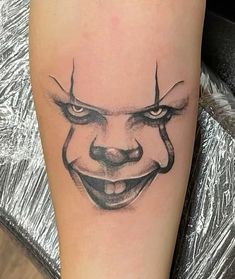 a close up of a person's leg with a clown face tattoo on it