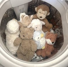 a bunch of stuffed animals are sitting in the basket on top of the washer