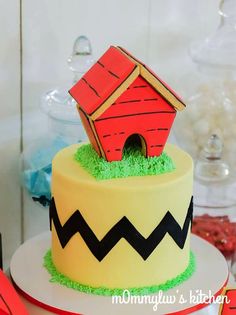 there is a cake that has been decorated with grass and a small house on top