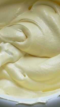 a white bowl filled with cream on top of a table