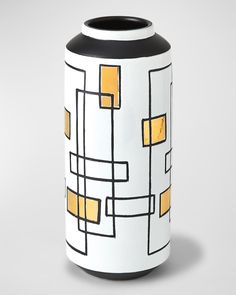 a black and white vase with yellow squares on it