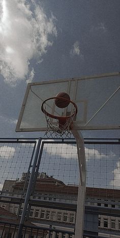 a basketball going through the hoop in front of a building