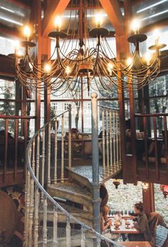 a spiral staircase in a restaurant with chandelier