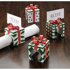 four gift boxes wrapped in green and white paper with red bows