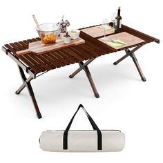 two picnic tables with one carrying bag and the other holding a wine bottle, glasses, and food