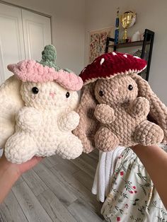 two crocheted stuffed animals are being held in front of the camera by someone's hand