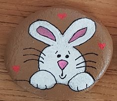 a painted rock with a rabbit on it's face and hearts around its eyes