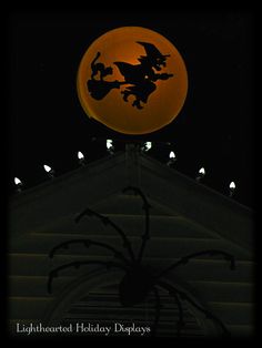 a full moon is in the sky above a building with a halloween decoration on it