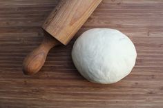 a ball of dough next to a rolling pin