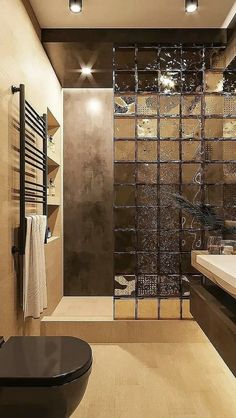 a bathroom with a glass shower door next to a sink and toilet in the corner