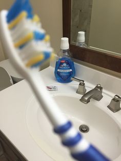 a toothbrush sitting on top of a bathroom sink next to a white countertop