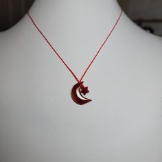 a necklace with a red string attached to it on a white mannequin head