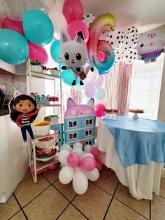 a party with balloons and decorations in the shape of houses, cats and kittens