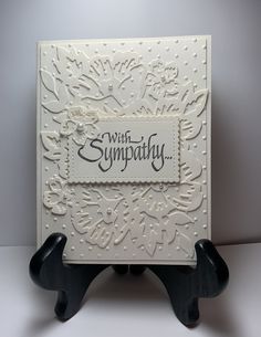 a white card with black rubber feet on it and the words sympathy written in cursive writing