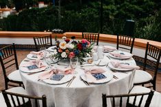 a table set with plates and napkins for an outdoor wedding reception at the resort