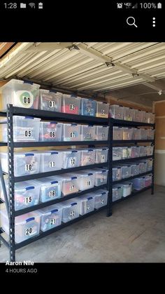 there are many plastic bins on the shelves in this storage room, and one is empty