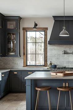 a kitchen with two stools next to an island