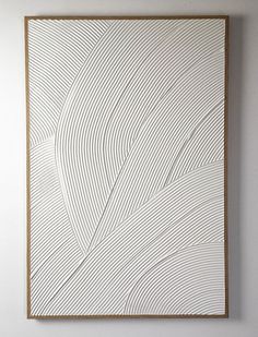 a white and brown abstract painting hanging on the wall