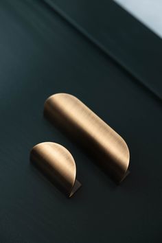 two brass door knobs on a black surface