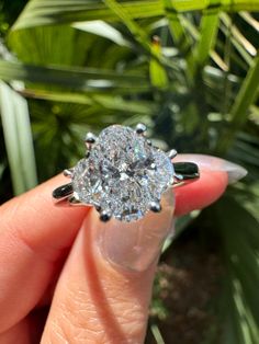 a close up of a person holding a ring with a diamond in it's center