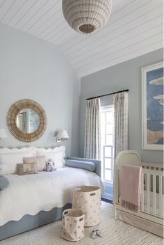 a baby's room with blue walls and white furniture