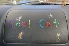 the back window of a car with stickers on it that spell out cats and letters