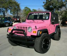 a pink jeep parked in a parking lot