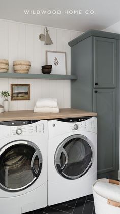 a washer and dryer in a laundry room with shelving on the wall