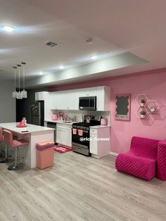 a kitchen with pink and white furniture in the center, along with an island counter