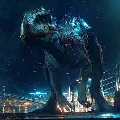 a large dinosaur standing on top of a metal platform in front of a city at night