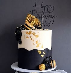 a black and white birthday cake with gold decorations