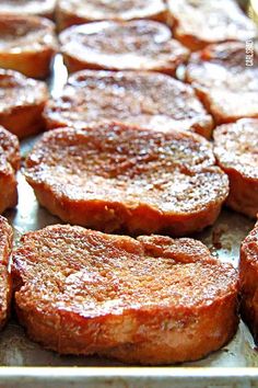 some hamburger patties are sitting on a baking sheet