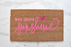 a door mat with the words hey there sunshine written in cursive yellow on it