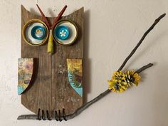 an owl made out of wood with two bowls and spoons on it's face