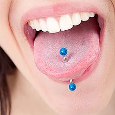 a woman's tongue with two piercings attached to the top of her tongue