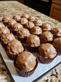 chocolate cupcakes with frosting sit on a tray in front of an oven