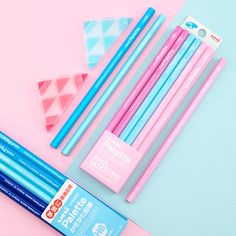 three pencils, two sharpener and one eraser are on a pink background